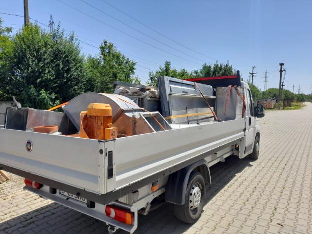 Fiat Ducato bena deschisa cu cabina alba incarcata cu marfa colorata